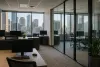 Unbranded modern insurance brokerage office with glass meeting rooms and a city view in natural morning light
