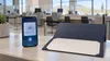 Smartphone showing an abstract secure birth credential beside a blank certificate folder at an Arizona motor-vehicle service counter