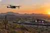 Camera drone flying near a generic Arizona outdoor event venue at sunset