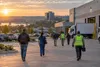 Workers approach a logistics and light-industrial complex in Arkansas at sunrise.