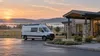 Illustrative view of an unmarked mobile health van outside a rural Arkansas clinic at sunrise.