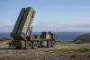Unbranded mobile missile launcher positioned at a coastal military test range in daylight