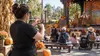 Interpreter signing beside a family-friendly outdoor Halloween stage at a generic California amusement park.
