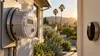 Residential electricity meter and home thermostat in warm late-summer light