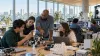 Graduate students and faculty collaborate with computers and research prototypes in a modern university laboratory