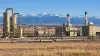 Oil and gas processing equipment on Colorado's eastern plains with the snow-covered Front Range in the distance.
