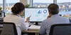 A healthcare professional and insurance reviewer examine abstract claims data on a computer in a Connecticut office.