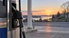 A generic gasoline pump and fuel nozzle at a quiet Connecticut service station at dawn.
