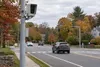 Conceptual view of an automated roadway camera beside a suburban Connecticut street in autumn
