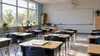 Illustrative empty Delaware classroom with rows of desks and notebooks in soft morning light.