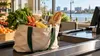 A grocery bag filled with staple foods beside a generic checkout counter.
