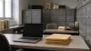 Unbranded government records office with gray filing cabinets, a blank laptop screen, and unlabeled folders in natural morning light