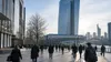 Commuters walking through Frankfurt's modern financial district in cool morning light