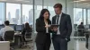 Banking professionals review an unmarked tablet in a modern financial-services office.