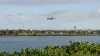 Generic passenger jet approaching an unbranded coastal Florida airport across a waterway in natural morning light