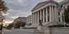 AI-generated editorial depiction of a neoclassical courthouse exterior with an American flag beneath an overcast sky.
