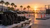 Illustrative empty Florida police-academy training ground with generic equipment, unmarked patrol cars and palm trees at sunrise.