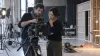 Two film professionals inspect an unbranded cinema camera inside an independent soundstage.
