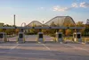 Unbranded amusement park parking entrance with a wooden roller coaster in the distance