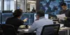 Cybersecurity investigators review abstract network activity in a modern office.