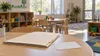 Conceptual image of an empty day care classroom with a plain medical folder and unlabeled vaccination record on a table.