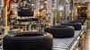 Illustrative modern tire factory with robotic equipment and unbranded tires on a production line.