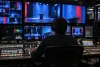 A broadcast technician monitors a generic podium feed from a television control room.