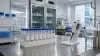 Unbranded vaccine research laboratory with sample vials and a pipette on a stainless-steel bench
