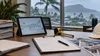 Insurance claims paperwork and a laptop beside a rain-streaked window overlooking Honolulu and Diamond Head