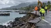 Storm-damaged coastal roadway and harbor infrastructure in Hawaii under overcast skies