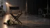 An empty director’s chair and white flowers on a quiet television soundstage