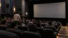 Moviegoers take their seats in a modern multiplex auditorium before a screening
