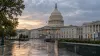 The United States Capitol reflected on rain-wet pavement beneath an overcast early-morning sky.