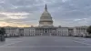 The U.S. Capitol viewed from an empty plaza under soft morning light.