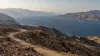 Arid mountain highlands overlooking a narrow maritime corridor with two distant cargo ships