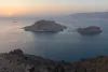 Arid Red Sea islands surrounded by calm blue water with a distant cargo vessel at dawn