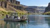 An environmental monitoring boat sampling calm water in Idaho’s Snake River canyon.