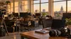 A quiet local newsroom with empty desks, computers and papers in soft daylight