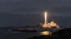 A small unbranded orbital rocket lifting off at night from a remote Arctic coastal launch pad