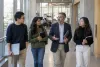 International graduate students and a faculty adviser walking through a university academic building