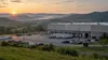 A distribution facility and parked trucks in the rolling Kentucky landscape at sunrise