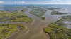 Aerial view of branching Mississippi River channels and coastal marshes in Louisiana with small unmarked fishing boats