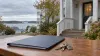 Illustrative view of house keys and a closed folder outside a modest Maine apartment building on an overcast autumn day.