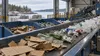 Unbranded packaging materials moving through a municipal recycling sorting facility