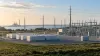 Unbranded battery storage and electrical substation infrastructure near a Maryland-style shoreline