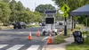 Unbranded roadside safety equipment, traffic cones, a crosswalk and a child passenger seat beside a Maryland-style roadway