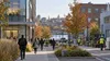 Workers and commuters cross a mixed office and light-industrial district in Massachusetts on an autumn morning.