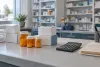 Unbranded prescription bottles, plain medicine cartons and a calculator on a pharmacy counter.