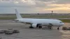 An unbranded cargo jet stands on a generic airport apron beside a runway