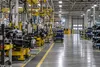 A quiet automotive manufacturing floor with assembly stations and industrial equipment.